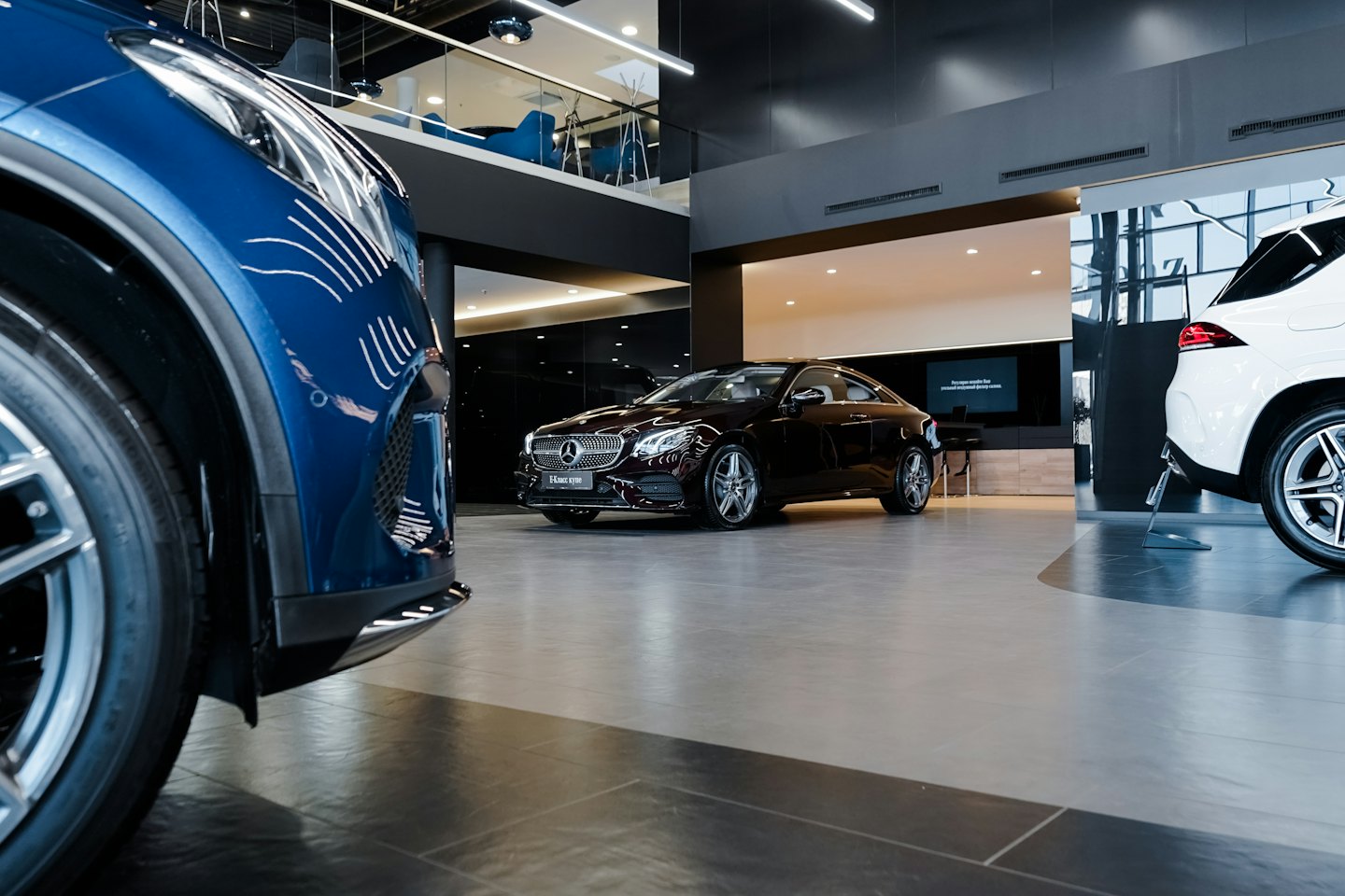 Luxury cars displayed in a modern showroom.